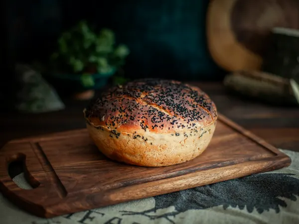 Tahta tezgâhta üstü çörek otlu yuvarlak ekmek