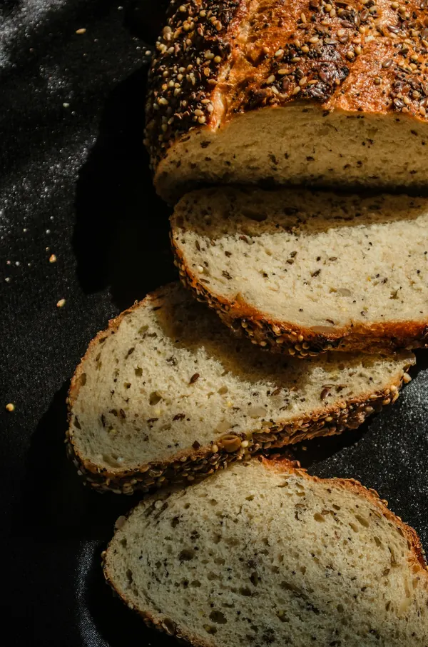 Koyu zeminde dilimlenmiş tohumlu ekmek